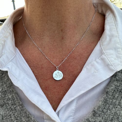 Et sølvsmykke rundt halsen.